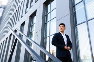 Asian businessman walks up the stairs of the office center, man hurries to a business photo