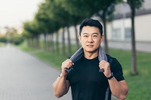 asian man after fitness workout and jogging happy man smiling shows thumb up and looks at camera photo