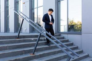 Asian businessman walks up the stairs of the office center, man hurries to a business photo