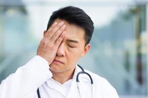 portrait of doctor asian man tired after work close up photo