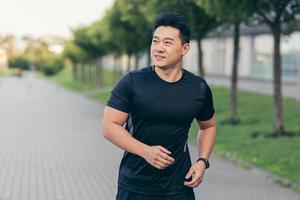atleta asiático masculino corriendo en el parque en una mochila antes del trabajo, corriendo en el parque foto
