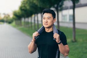 asian man after fitness workout and jogging happy man smiling shows thumb up and looks at camera photo