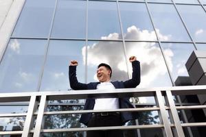 Asian businessman boss stands near his office center on the balcony in a dark color business photo