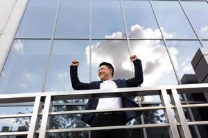 Asian businessman boss stands near his office center on the balcony in a dark color business photo