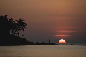 Sunset ocean view. Sun above the sea on orange sky. photo