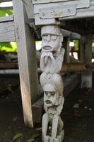 the legs of a chair with unique carvings in the form of miniature humans photo