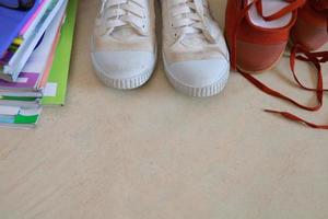 los zapatos de los estudiantes y los libros de texto de los niños están dispuestos en el suelo para prepararse para la escuela mañana. foto
