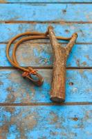 Slingshot on old blue wood photo