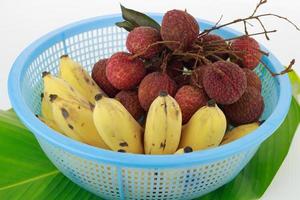 Bananas and lychees in a blue basket photo