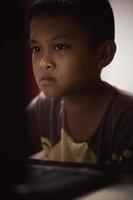 un niño está estudiando en línea en su computadora portátil en casa. foto