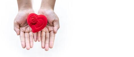 caja roja en forma de corazón en la mano del niño, concepto de amor, cuidado de la salud, donación y concepto de seguro familiar, día mundial del corazón, día mundial de la salud, concepto foto