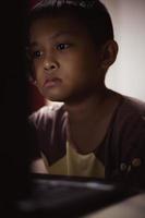 un niño está estudiando en línea en su computadora portátil en casa. foto