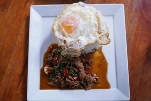 Stir fried beef with basil with fried egg on white plate It's a simple a la carte. that Thai people are very popular. photo