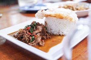 Stir fried beef with basil with fried egg on white plate It's a simple a la carte. that Thai people are very popular. photo