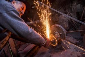 the blacksmith polishing metal products photo