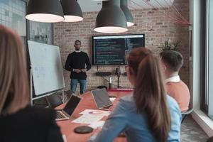 Leader give a business presentation at an office conference meeting, businessman coach mentor explains graph chart on board corporate group workshop training in boardroom. Selective focus photo