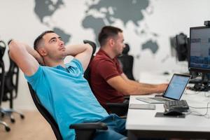 A time for relax. Young tired casual businessman relaxing at the desk in his office. Selective photo