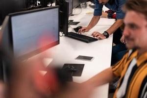 Group of Casual business man working on desktop computer in modern open plan startup office interior. Selective focus photo