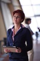 business woman  at office with tablet  in front  as team leader photo