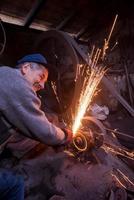 the blacksmith polishing metal products photo