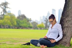 Beautiful young woman with  tablet in park photo