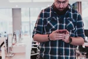 Office manager work in coworking space using smartphone analyzing online market trends, focused man worker reading financial news or browsing internet on phone. Technology concept photo
