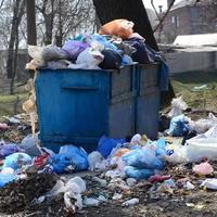 el bote de basura está lleno de basura y desechos. retiro intempestivo de basura en zonas pobladas foto