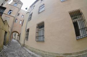 Narrow street with a path of paving stones. Passage between the old historical high-rise buildings in Lviv, Ukraine photo