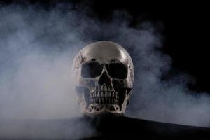 Halloween human skull on an old wooden table over black background. Shape of skull bone for Death head on halloween festival which show horror evil tooth fear and scary, copy space photo