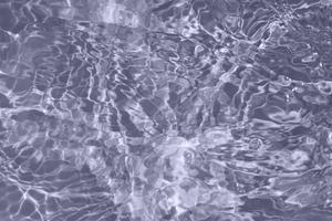 Defocus blurred transparent blue colored clear calm water surface texture with splash, bubble. Shining blue water ripple background. Surface of water in swimming pool. Blue bubble water shining. photo