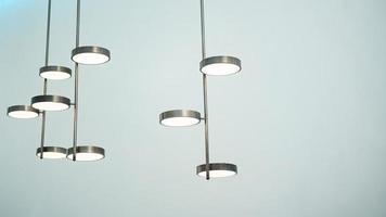 A silver metal lamp in cylinder shape hangs on the ceiling. photo