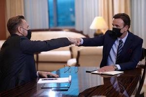 business people wearing  face mask on meeting and handshake photo