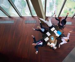 top view of business people group throwing dociments in air photo