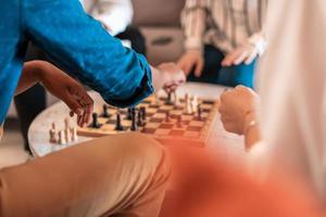 Multiethnic group of business people playing chess while having a break in relaxation area at modern startup office photo