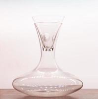 Transparent pitcher with glass on wood table with white background. photo