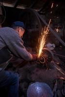 the blacksmith polishing metal products photo