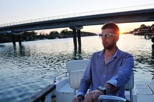 portrait of happy young man on boat photo