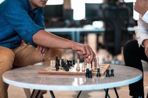 Multiethnic group of business people playing chess while having a break in relaxation area at modern startup office photo