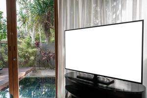 interior de la habitación, ventana grande con cortinas blancas, vistas a la piscina, pantalla blanca de televisión simulada en la mesa. foto