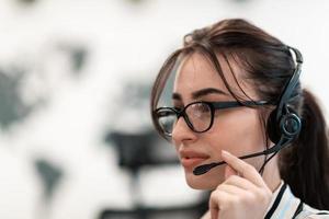 concepto de negocio y tecnología: operadora de la línea de ayuda con auriculares en el centro de llamadas. mujer de negocios con auriculares que trabajan en un centro de llamadas foto