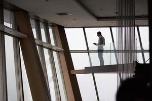 young successful business man in penthouse apartment working on tbalet photo