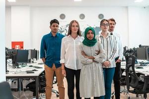 Portrait of young excited multiethnics business team of software developers standing and looking at camera at modern startup office photo