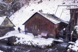 dos herreros confiados frente al molino de agua foto