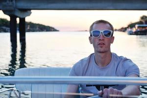 portrait of happy young man on boat photo