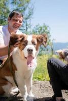 young couple travelling with dogs at the mountains, St.Bernard dog and yourkshire terrier photo