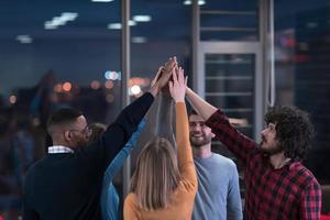 Overjoyed young multiethnic businesspeople have fun celebrate shared business success or victory in office. Smiling multiracial diverse employees feel excited win get good results. Teamwork concept. photo