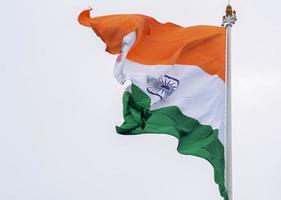 India flag flying high at Connaught Place with pride in blue sky, India flag fluttering, Indian Flag on Independence Day and Republic Day of India, tilt up shot, Waving Indian flag, Har Ghar Tiranga photo