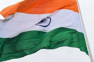 India flag flying high at Connaught Place with pride in blue sky, India flag fluttering, Indian Flag on Independence Day and Republic Day of India, tilt up shot, Waving Indian flag, Har Ghar Tiranga photo