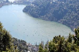 Full view of Naini Lake during evening time near Mall Road in Nainital, Uttarakhand, India, Beautiful view of Nainital Lake with mountains and blue sky photo