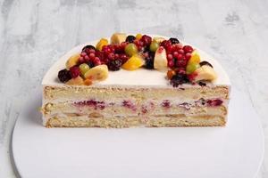 A top view shot of sliced half fruit cake on a white plate photo